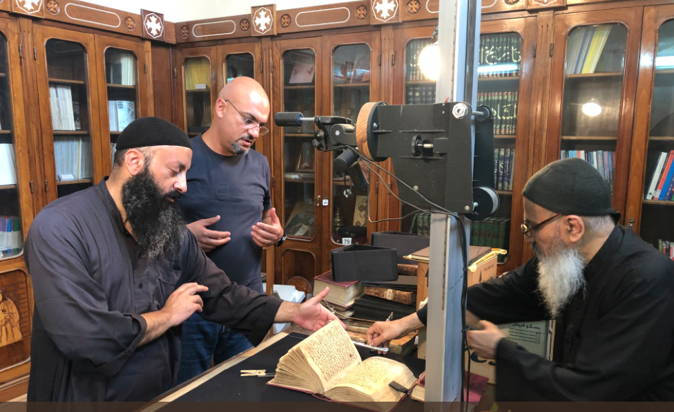 Monks of Saint Macarius digitizing their manuscripts, with HMML’s Director of Field Operations for the Middle East, Africa, & South Asia, Walid Mourad